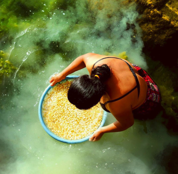 Photo of Guatamalan women washing corn kernels in the river 